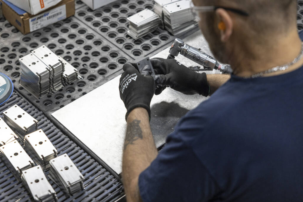 detail d'un ouvrier qui travaille sur des pièces métalliques dans une usine